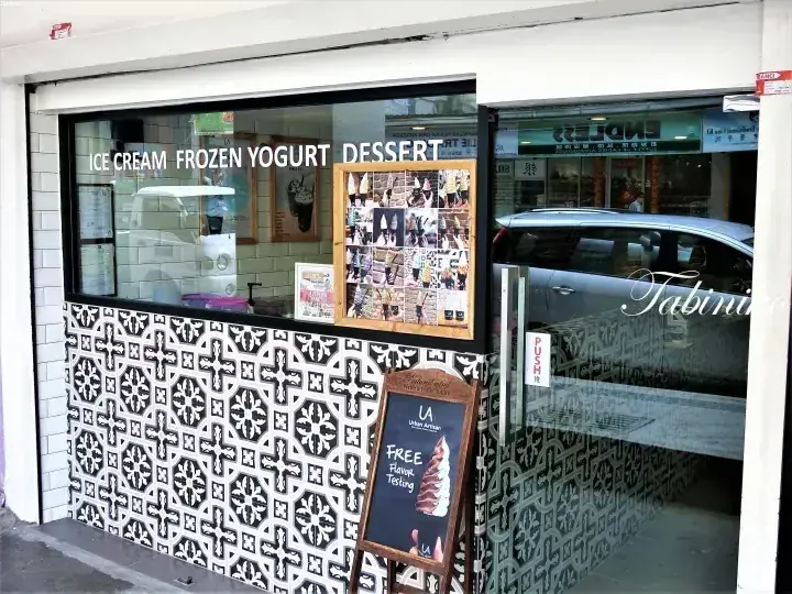 アイスクリームやフローズンヨーグルトを提供する「La Maison Gelato」の店舗外観。タイル調の外壁と無料試食の看板が特徴です。