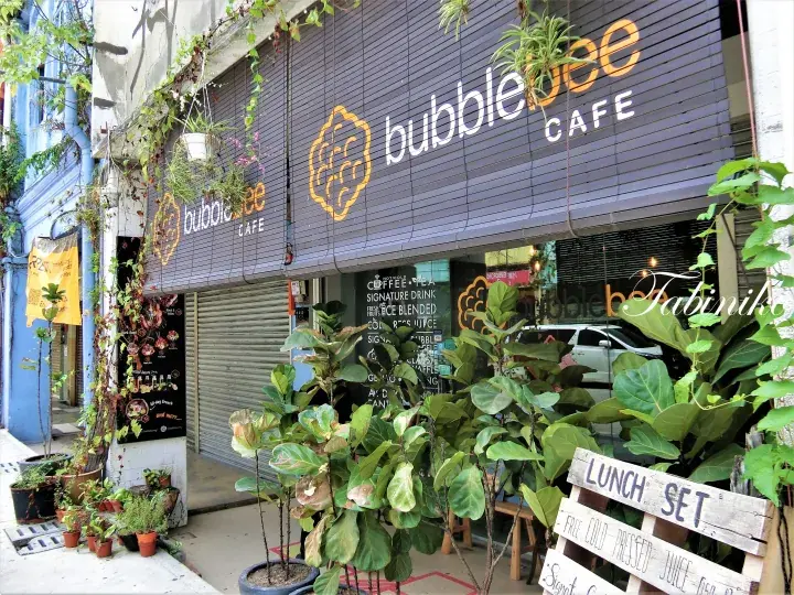 bubblebee CAFE storefront with wooden signage, lush green plants, and a lunch set board outside.