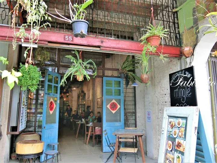Entrance to Publika Mingle cafe with hanging plants and blue doors