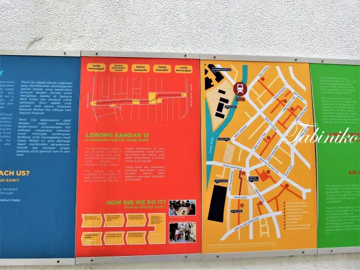 Informational display board showing Lorong Bandar 13 project details, maps, and community engagement process.