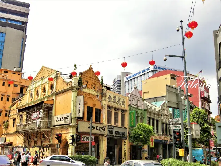 Colorful heritage shophouses in Kuala Lumpur&rsquo;s Chinatown with red lanterns and Bangkok Bank signage.
