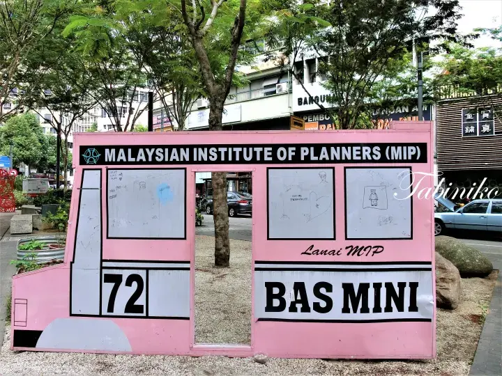 Pink Malaysian Institute of Planners (MIP) mini bus photo frame display in an outdoor park setting.
