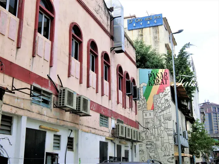 D&rsquo; Oriental Inn hotel sign above a colorful PASAR KARAT mural on a heritage shophouse in Malaysia.