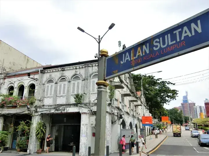 クアラルンプールのJalan Sultanの街路標と、歩行者が行き交う歴史的なショップハウスが並ぶ通り。