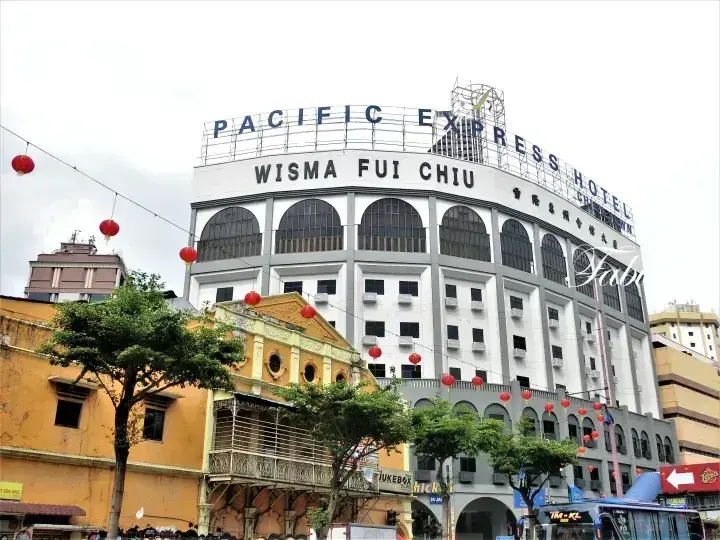 マレーシアの街並みにある太平洋エクスプレスホテル・ウィスマ・フイ・チウの外観と赤い提灯。