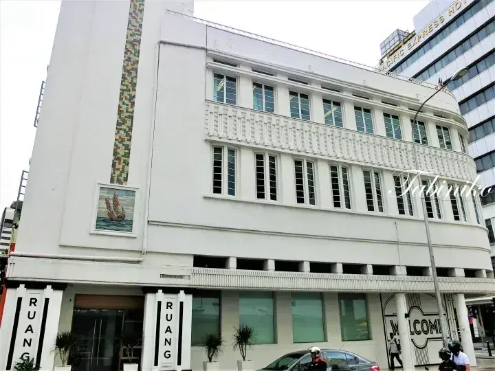 GRAND EXPRESS HOTELの近くにある、RUANGの看板とモザイク壁画が特徴的なアールデコ調の白い建物。