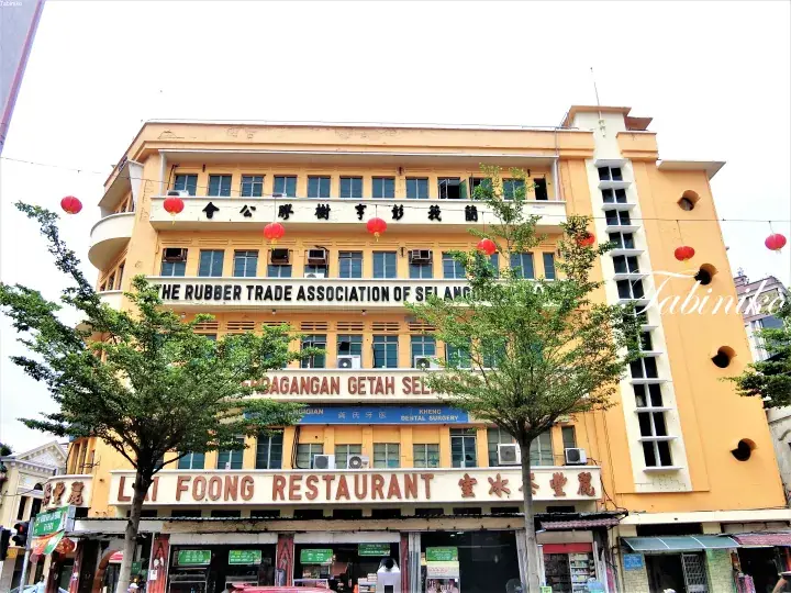 Yellow heritage building housing the Rubber Trade Association of Selangor and Li Foong Restaurant, decorated with red lanterns.