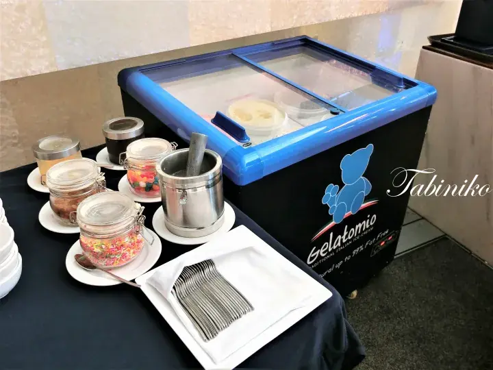 トッピングとスプーンが並ぶGelatomioアイスクリームフリーザー