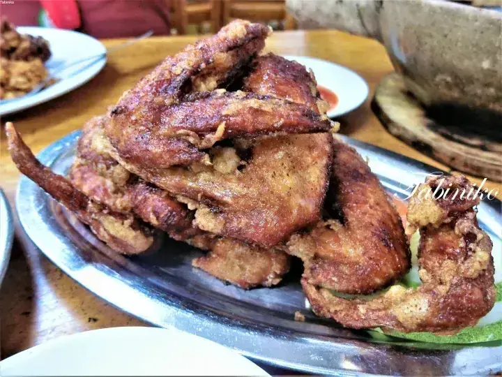 マレーシアの料理店で、金属製の皿に山盛りにされたカリカリの唐揚げチキンウィング。