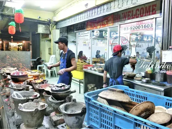 マレーシアの屋台で、炭火で土鍋飯を調理するシェフたち。