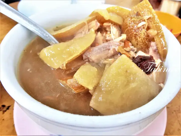 A bowl of traditional Malaysian herbal soup with pork, preserved vegetables, and red dates.
