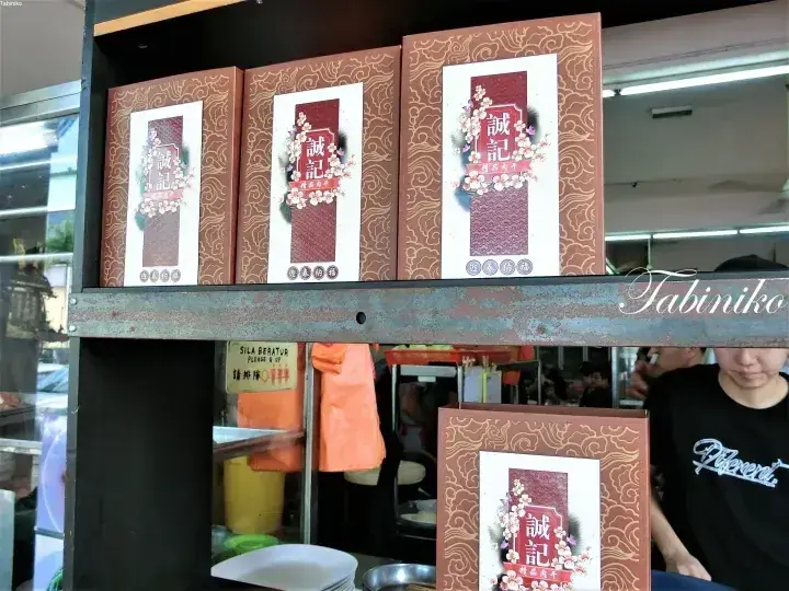 マレーシアの屋台で金属製の棚に並べられた「誠記」の商品箱。