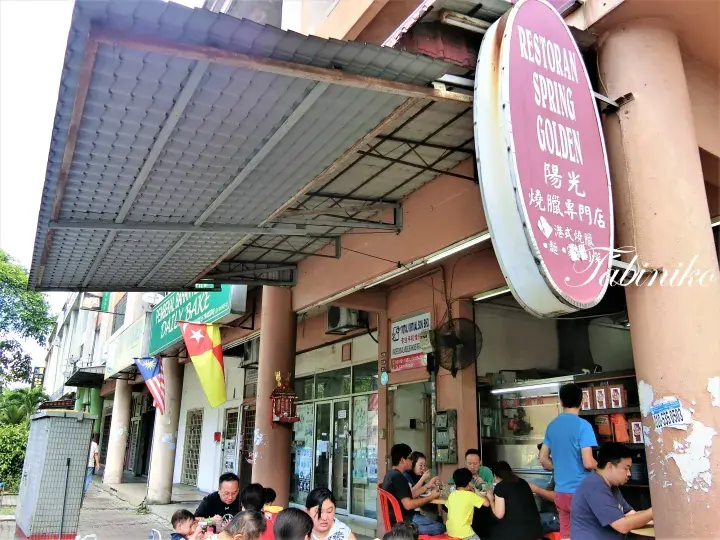 Restoran Spring Golden storefront with customers dining outside and a red oval sign.