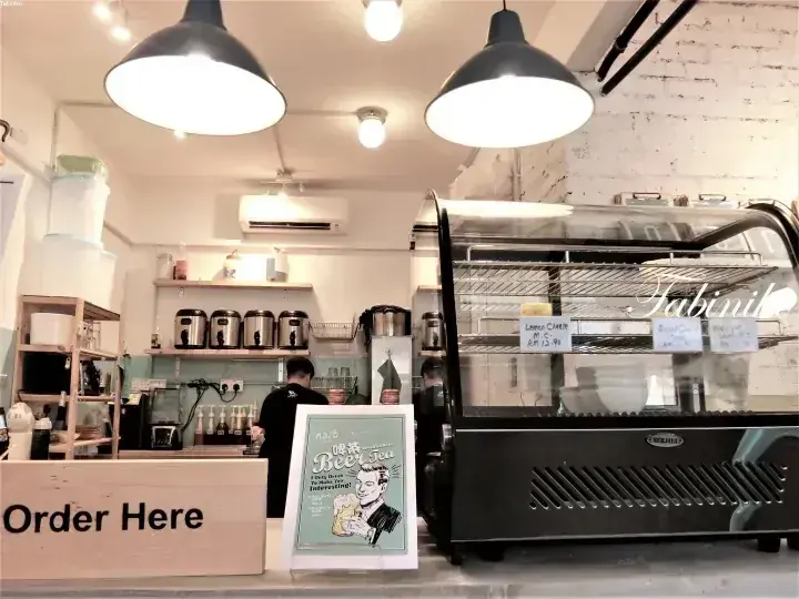 注文カウンター、ケーキのショーケース、コーヒー準備エリアが見えるFabinilカフェの店内。