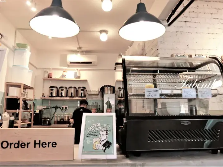 Interior of Fabinil cafe showing the order counter, display case with cakes, and coffee station.