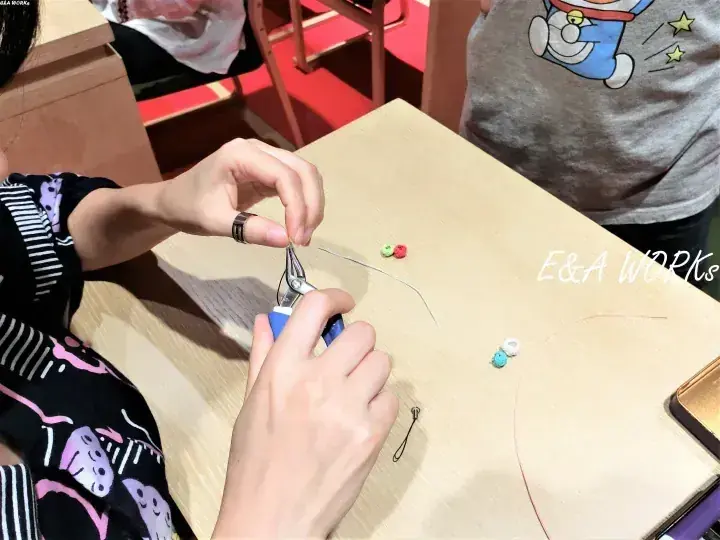 E&A Worksのワークショップで、ビーズを使ってアクセサリー製作を行う手元。