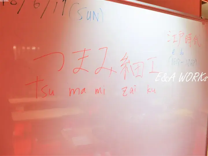 Whiteboard with handwritten Japanese text ‘Tsumami Zaiiku’ and ‘Edo Period’ in red and blue markers.