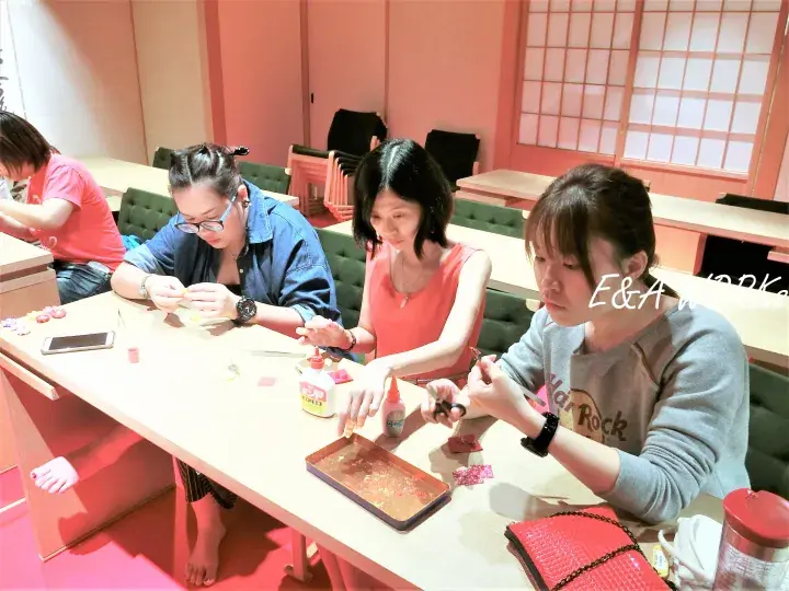 Guests participate in a craft workshop at E&A Workshop in Malaysia, focusing on handmade accessories at a shared table.