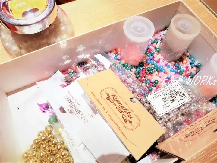 カラフルなビーズや金具、SSFブランドのパッケージが入ったクラフト用品の箱。