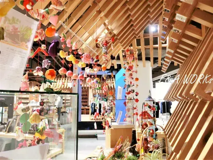 木造天井のブティック店内に吊るされたカラフルな手作りオーナメント。