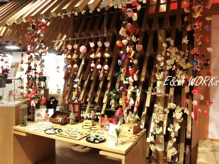 E&A WORKSの店内に木製フレームから吊るされた色とりどりの手作りクラフトと装飾品。