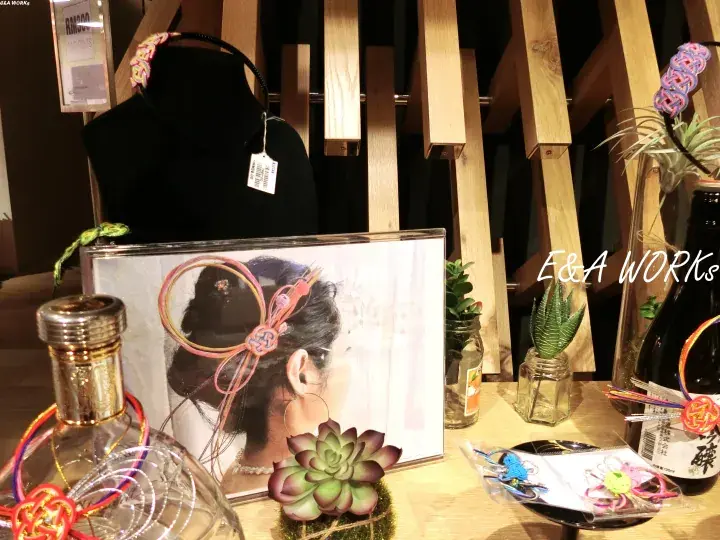 E&A WORKS handmade hair accessories displayed on a wooden stand with succulents and decorative bottles.