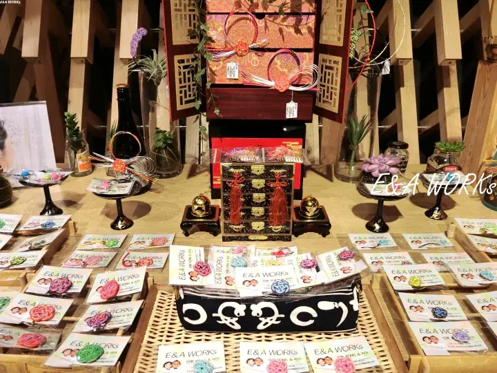 E&A WORKS handmade accessories displayed on a wooden stall with traditional Chinese lanterns and decorative boxes.