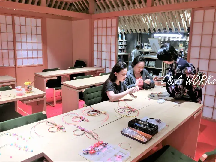 Guests participate in a traditional craft workshop at E&A Works, surrounded by Japanese-style interior decor.
