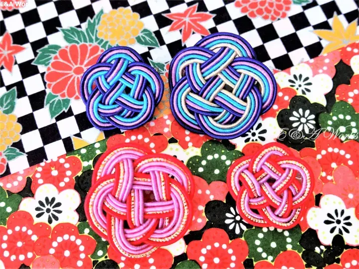 Colorful traditional Japanese knot crafts displayed on vibrant patterned fabric backgrounds.
