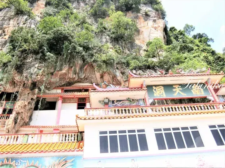 A Chinese temple built into a limestone cliff face with a sign reading ‘Nantian Dong’.