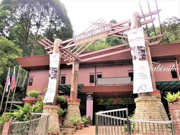 Entrance archway of Taman Eko Rimba KL with wooden structure and banners at the forest park.