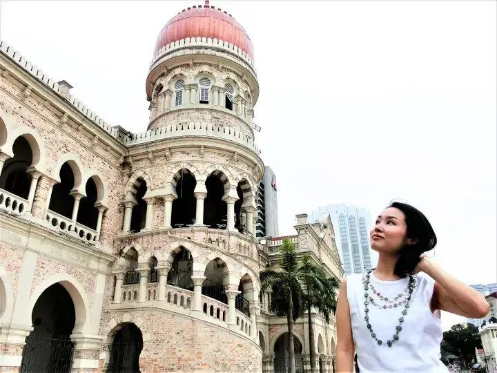 Woman posing in front of the Sultan Abdul Samad Building in Kuala Lumpur, Malaysia.