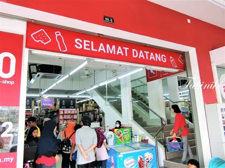 入り口に赤い「SELAMAT DATANG」の看板があるコンビニエンスストアへ入る顧客たち。