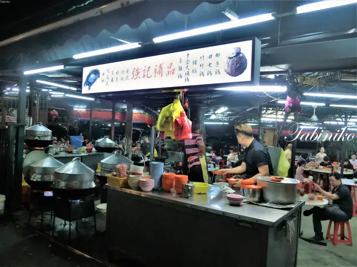 マレーシアの屋台街で伝統的なスープを提供する「強記補品」の活気ある夜間の屋台。