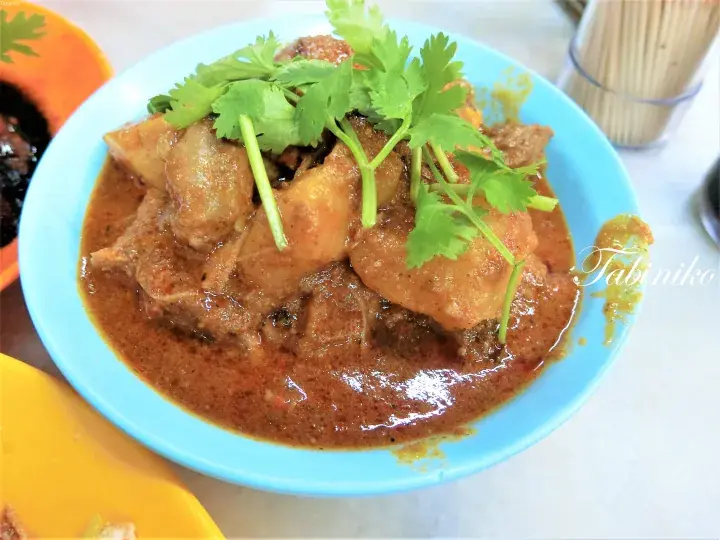新鮮なパクチーをトッピングした、肉とジャガイモがたっぷり入った濃厚なカレー。