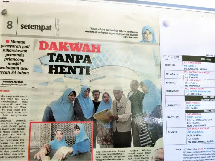 青いヒジャブを着た女性たちと男性のグループ写真が掲載され、「DAKWAH TANPA HENTI」という見出しの新聞記事。
