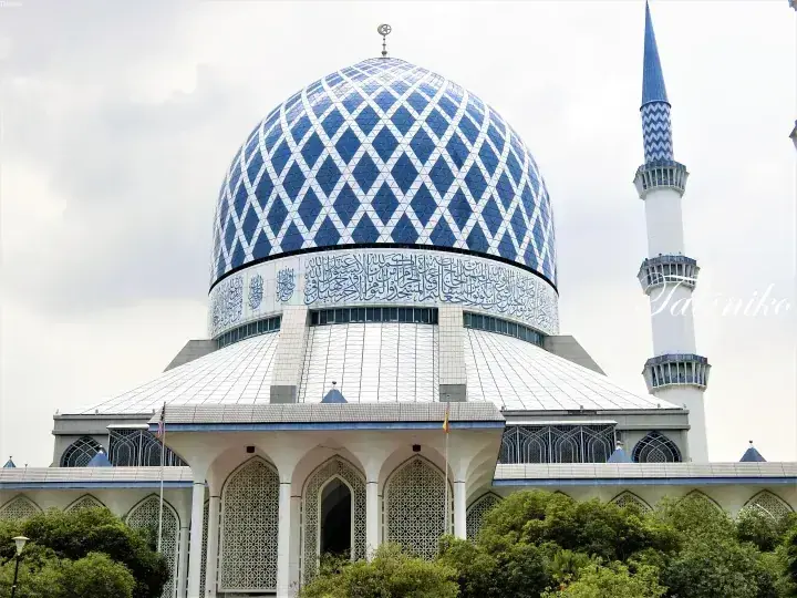 Blue and white patterned dome and minaret of the Sultan Salahuddin Abdul Aziz Shah Mosque in Shah Alam, Malaysia.