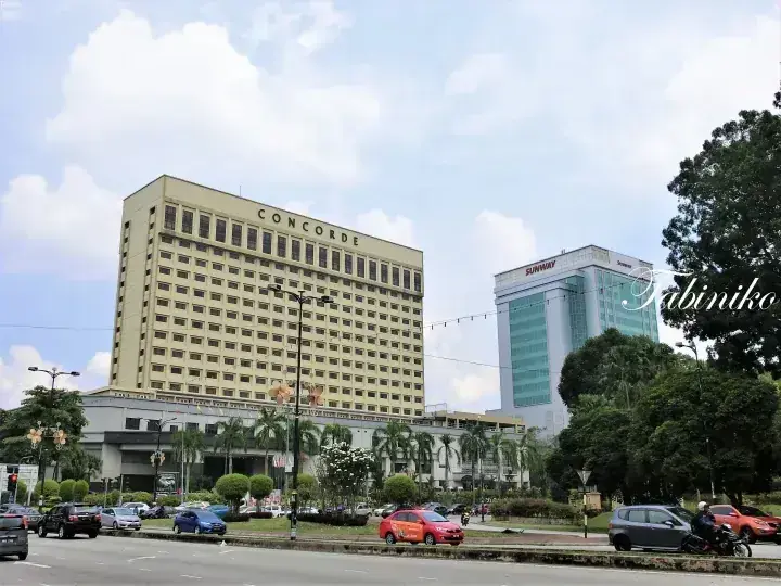 Concorde Hotel and Sunway building in Kuala Lumpur with traffic and palm trees