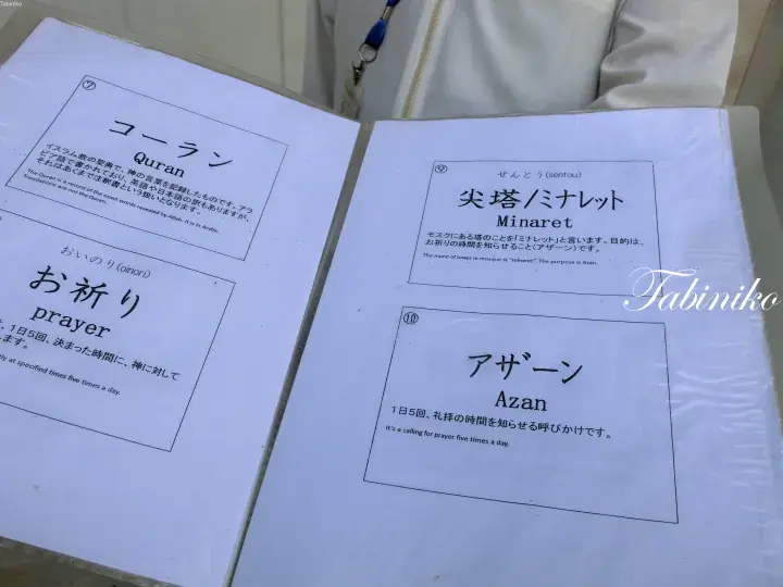コーラン、ミナレット、アザーンなどのイスラム教用語が日本語と英語で記載された開かれた冊子。