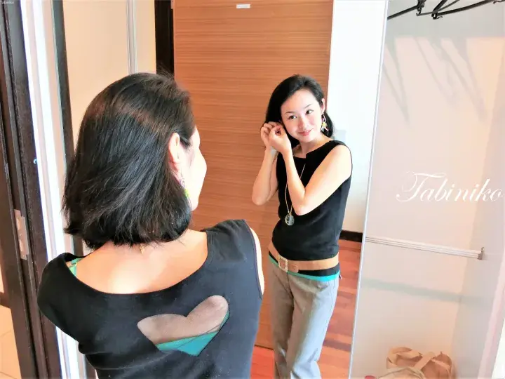 モダンな物件の中で鏡に映る女性。ガラスには「Tabiniko」という文字が見えます。