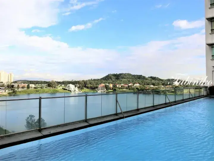 Infinity pool overlooking a lake and green hills from a modern apartment balcony in Malaysia.