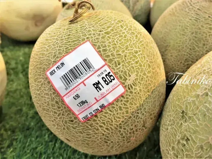 Close-up of a rock melon with a price tag showing RM 8.05 from Fruit Co Sdn Bhd in Malaysia
