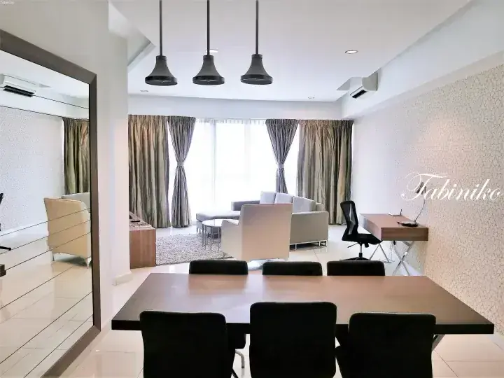 Modern dining area with wooden table and black chairs, leading to a bright living room with grey sofa and large windows.