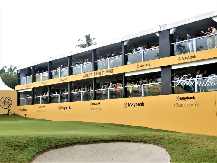 Yellow Maybank Championship hospitality suite with spectators watching the golf course.