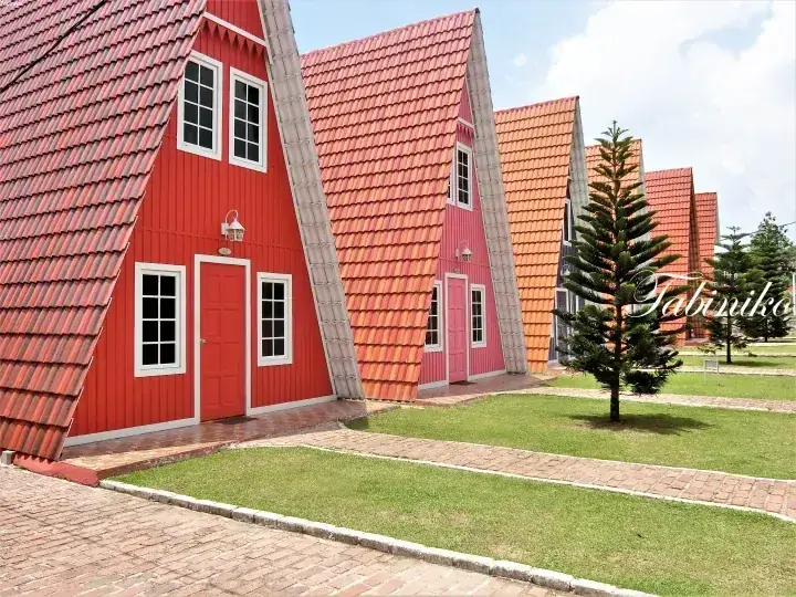 マレーシアの物件にある赤やピンクの外壁と瓦屋根が特徴的なA字型の住宅。