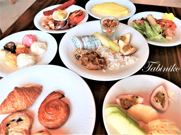 パスタリー、ディムサム、オムレツ、野菜のグリル、トロピカルフルーツが並ぶ朝食ビュッフェの盛り合わせ。