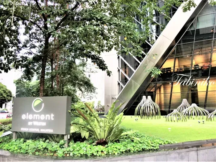 Sign for Element by Westin Kuala Lumpur, Malaysia, set against a modern glass building and landscaped garden.