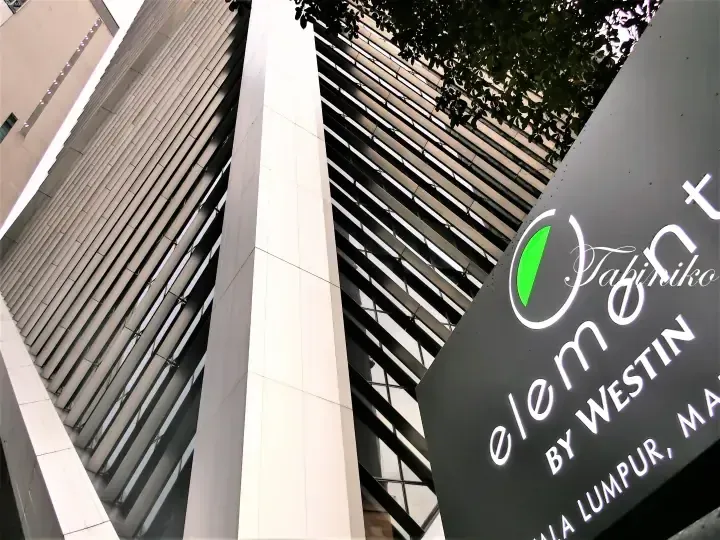 Low-angle view of the Element by Westin Kuala Lumpur, Majestic Hotel sign against the modern building facade.