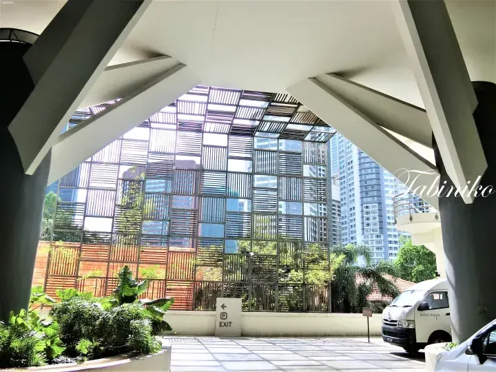 Hotel Maya Kuala Lumpur entrance featuring modern architecture, glass facade, and a branded shuttle van.