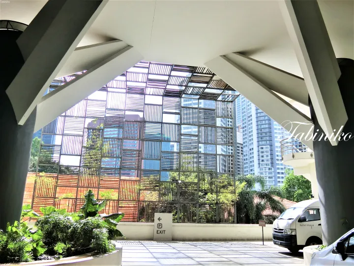 モダンな建築とガラスのファサードが特徴的なHotel Maya Kuala Lumpurのエントランス。ブランデッドシャトルバンも写っています。